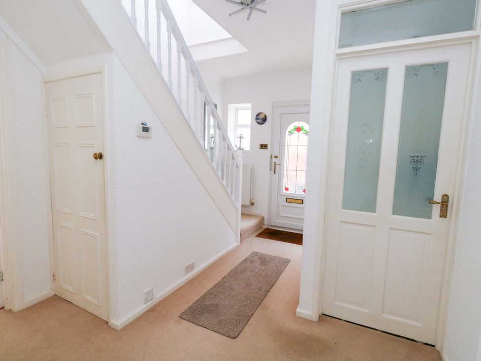 A hallway with a staircase and doors at 15 Coombe Avenue