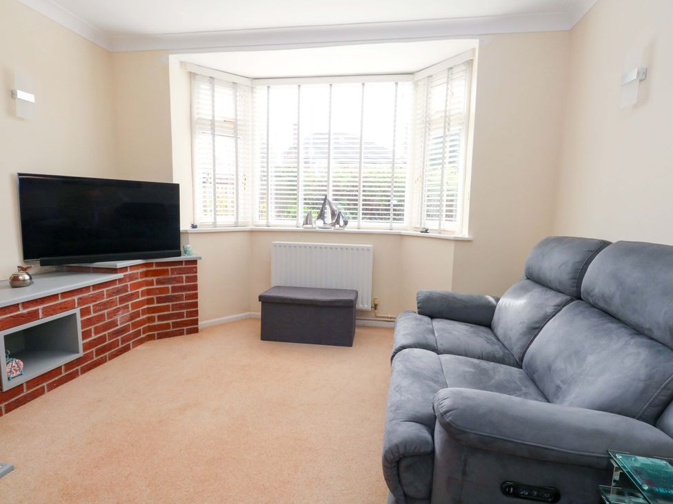 A living room with a television and sofa at 15 Coombe Avenue