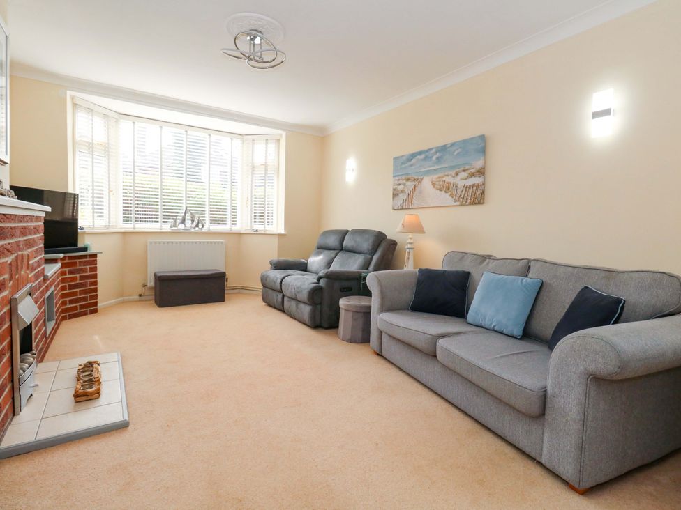 A living room with a sofa and recliner chair at 15 Coombe Avenue