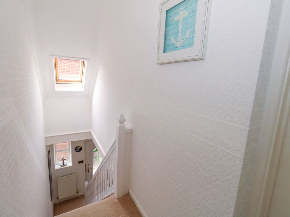 A staircase with a window and picture frame in a hallway at 15 Coombe Avenue