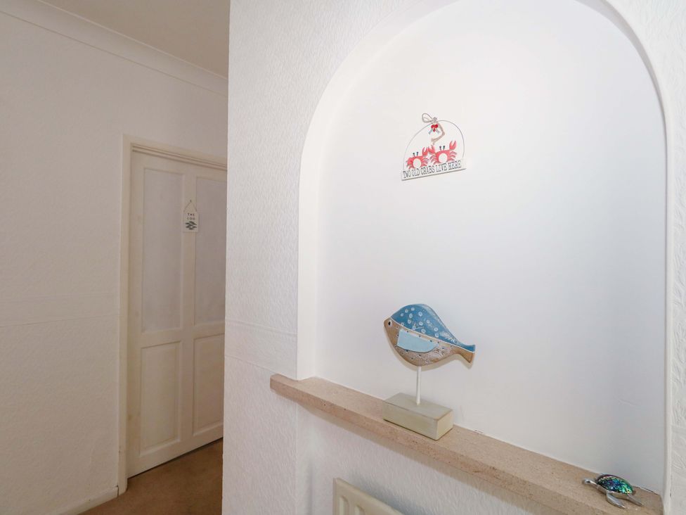 A hallway with a decorative bird and wall sign at 15 Coombe Avenue