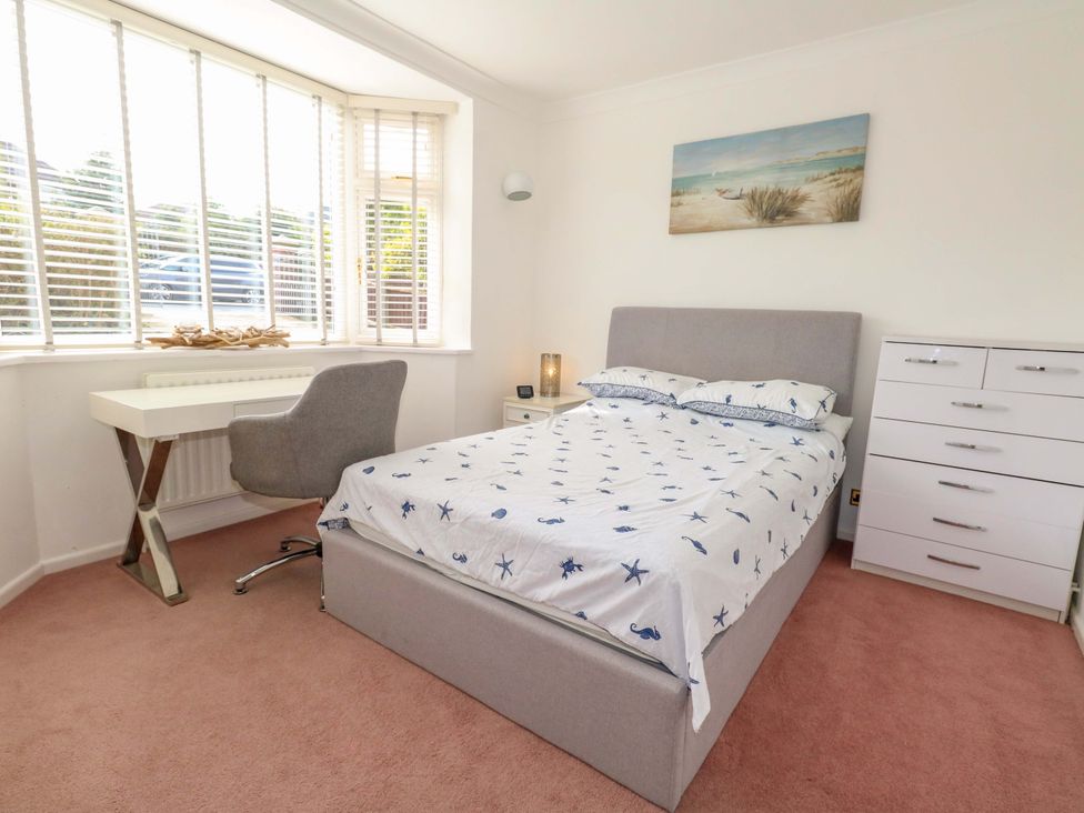 A bedroom with a bed, desk, and wardrobe at 15 Coombe Avenue