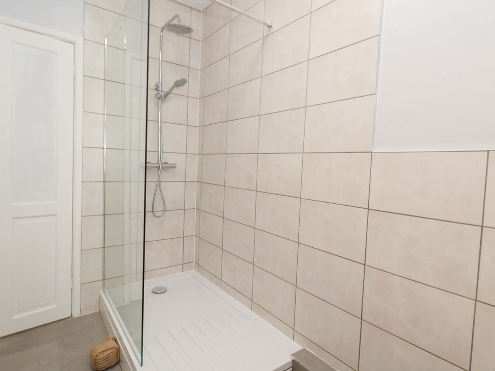 A shower with glass panel and tiled walls at 15 Coombe Avenue
