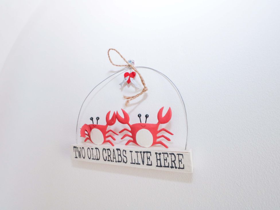 A decorative sign with crabs stating two old crabs live here