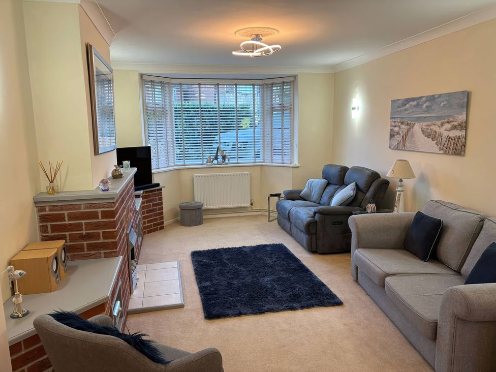 A living room with seating and television at Tudor Rose in Weymouth