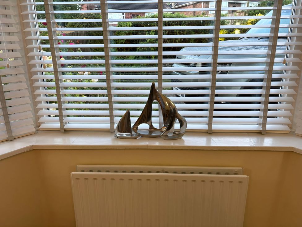 A living room with a decorative item on the window sill at Tudor Rose Weymouth