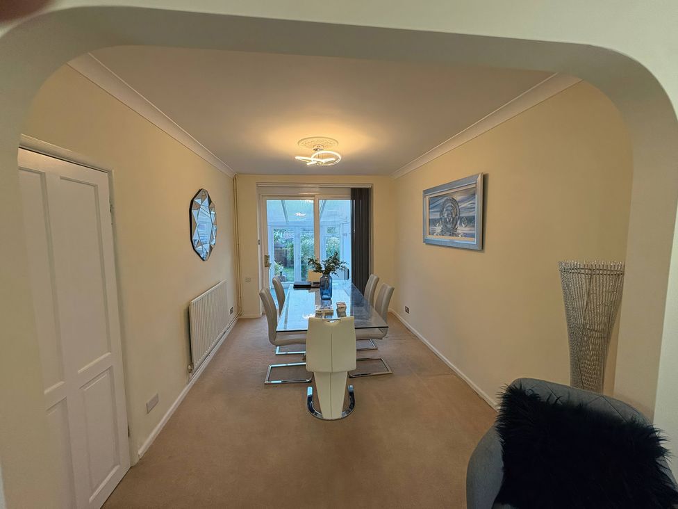A dining room with a table and chairs at Tudor Rose in Weymouth