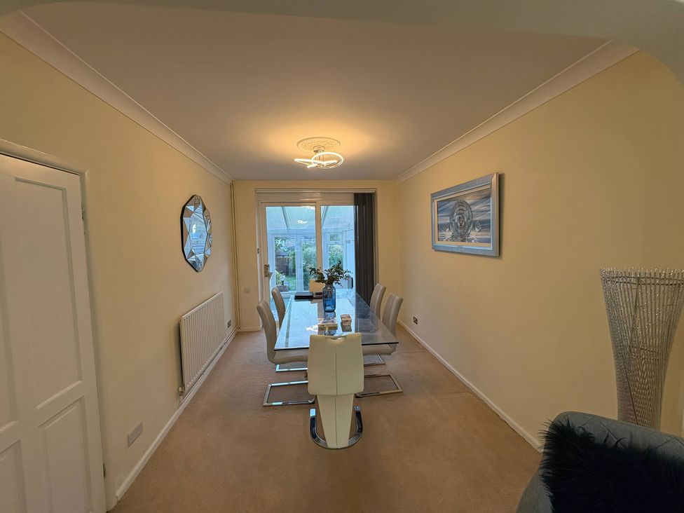 A dining room with a table and chairs at Tudor Rose in Weymouth