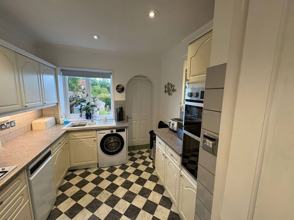 A kitchen with cabinets and appliances at Tudor Rose in Weymouth