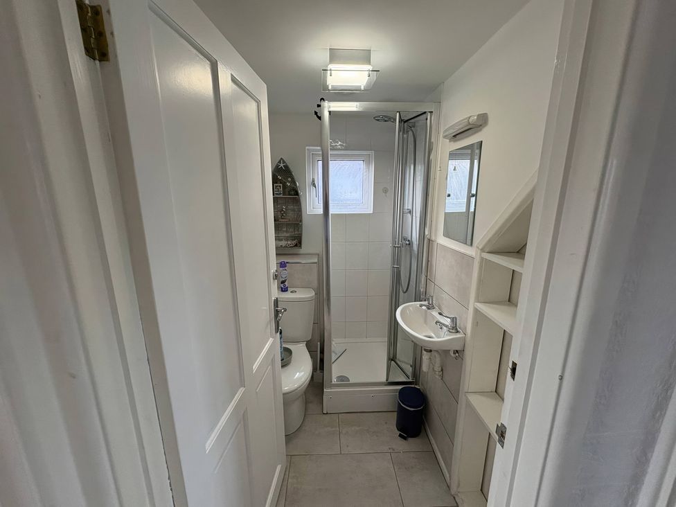 A bathroom with a shower, toilet, and sink at Tudor Rose in Weymouth