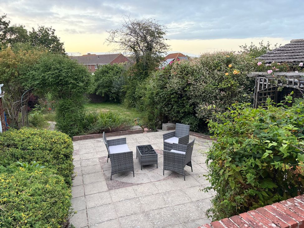 A garden with chairs and a table at Tudor Rose in Weymouth