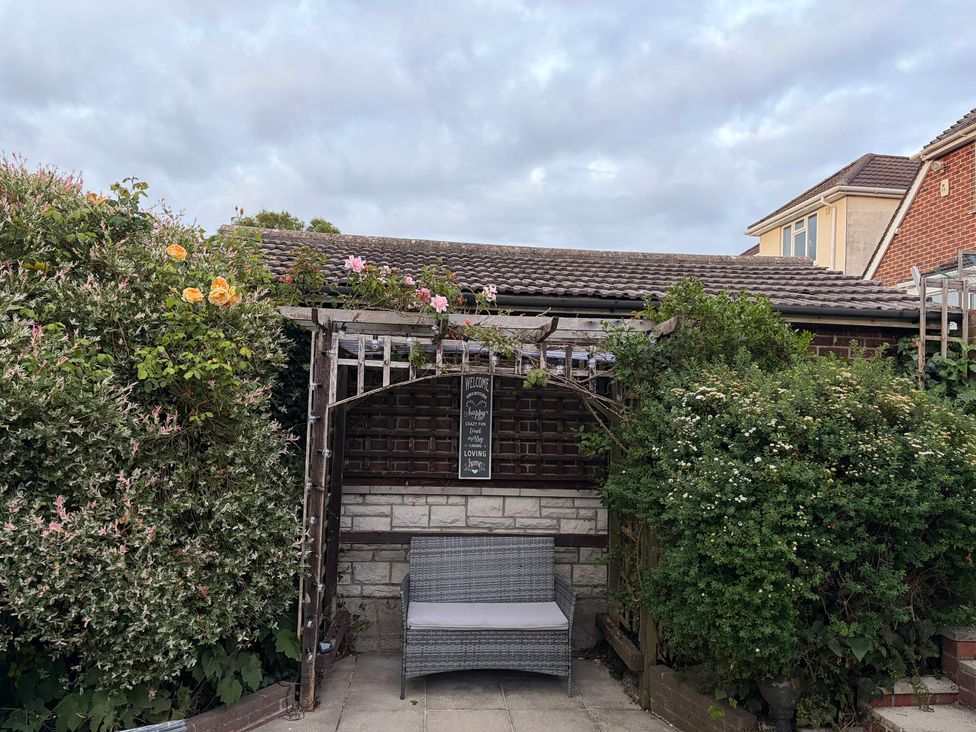 A garden with a bench and flowers at Tudor Rose in Weymouth