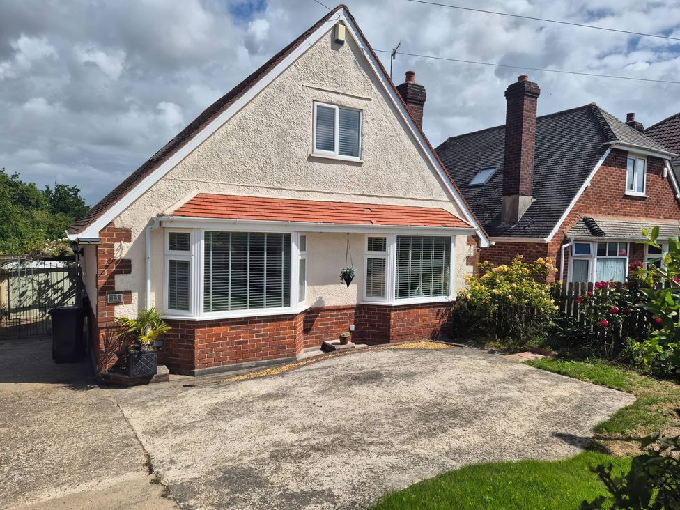 A house with a driveway and garden at Tudor Rose in Weymouth