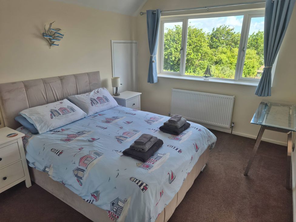A bedroom with a bed and window at Tudor Rose in Weymouth