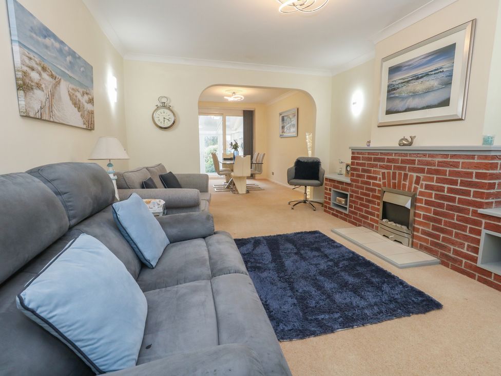 A living room with a sofa and a fireplace at Tudor Rose in Weymouth