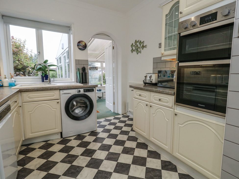 A kitchen featuring a washing machine and oven at Tudor Rose in Weymouth