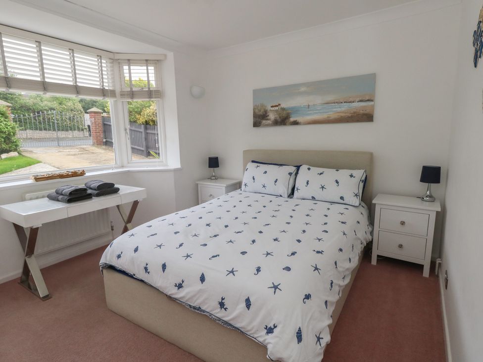 A bedroom with a bed and bedside tables at Tudor Rose in Weymouth