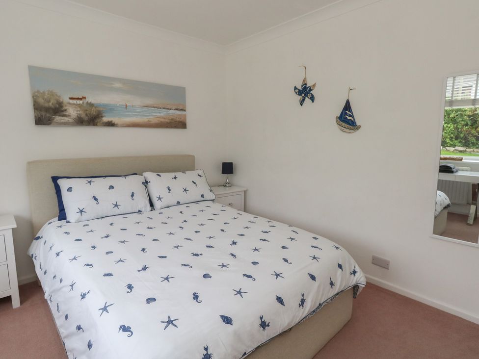 A bedroom with a bed and bedside table at Tudor Rose in Weymouth