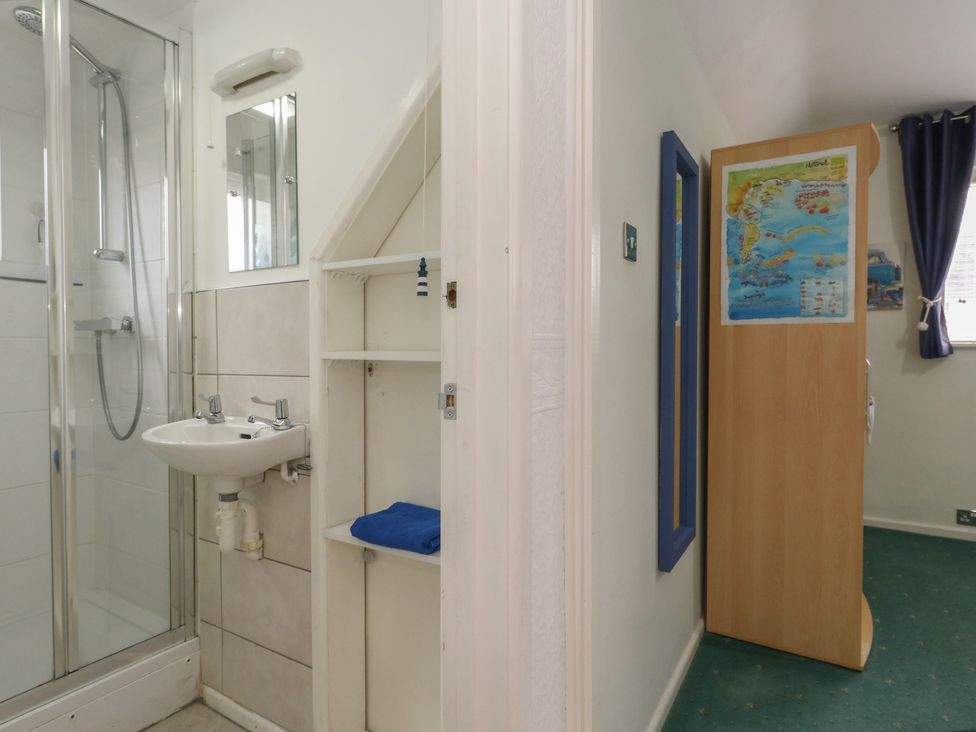 A bathroom with a shower and sink at Tudor Rose in Weymouth