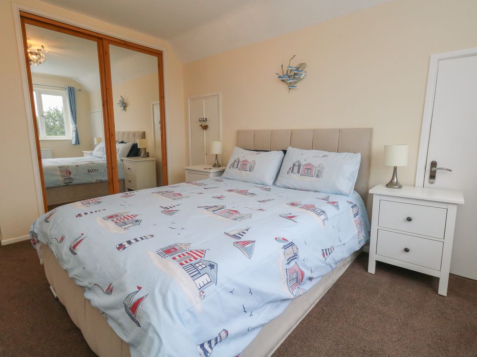 A bedroom with a bed and bedside table at Tudor Rose in Weymouth