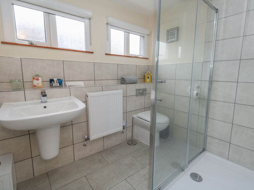 A bathroom with a shower, toilet, and sink at Tudor Rose in Weymouth