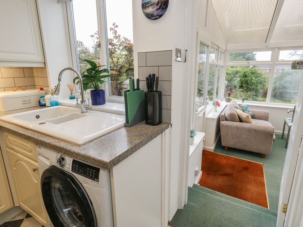 A kitchen with a sink and washing machine at Tudor Rose in Weymouth