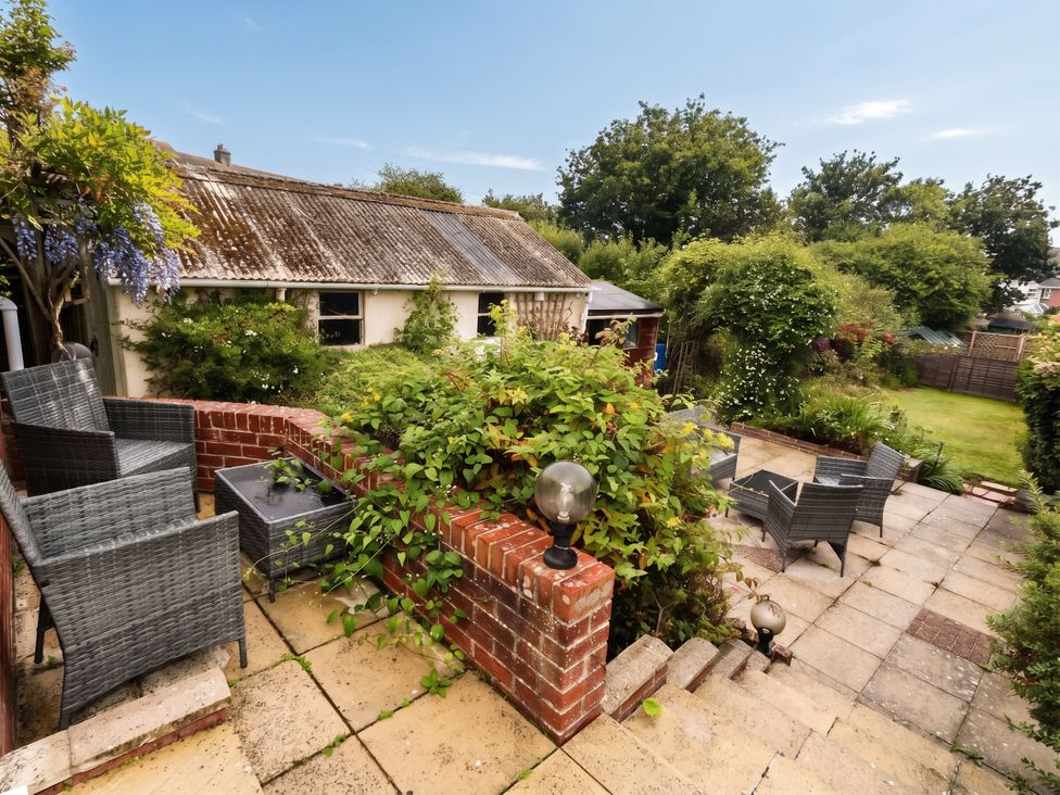 A garden with seating area and plants at Tudor Rose in Weymouth
