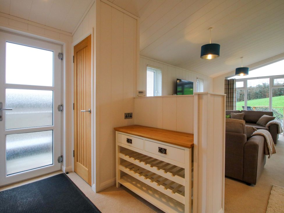 An entrance area with a wine rack and a television at 5 Hillview Lodges in Cleobury Mortimer