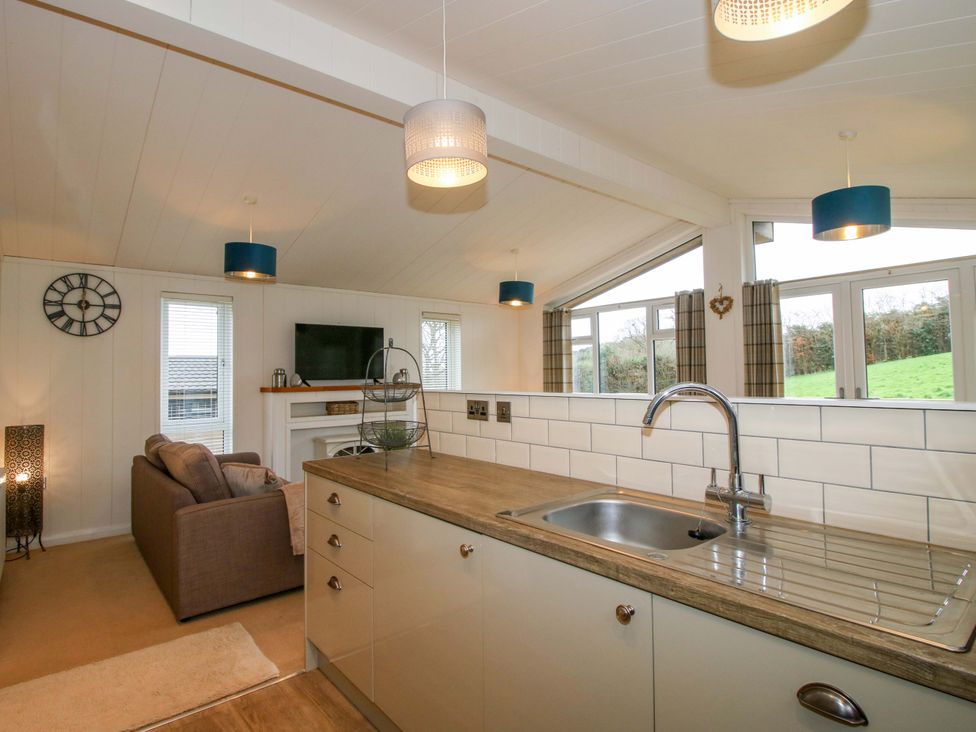 A kitchen and living room combined space with a sofa and television at 5 Hillview Lodges in Cleobury Mortimer