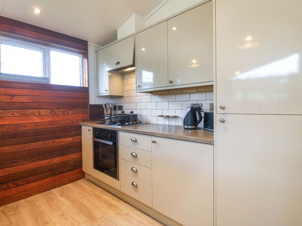 A kitchen with a countertop, cabinets, and a cooktop at 5 Hillview Lodges in Cleobury Mortimer