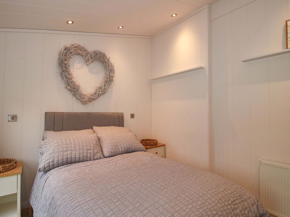 A bedroom with a bed and wall decor at 5 Hillview Lodges Cleobury Mortimer