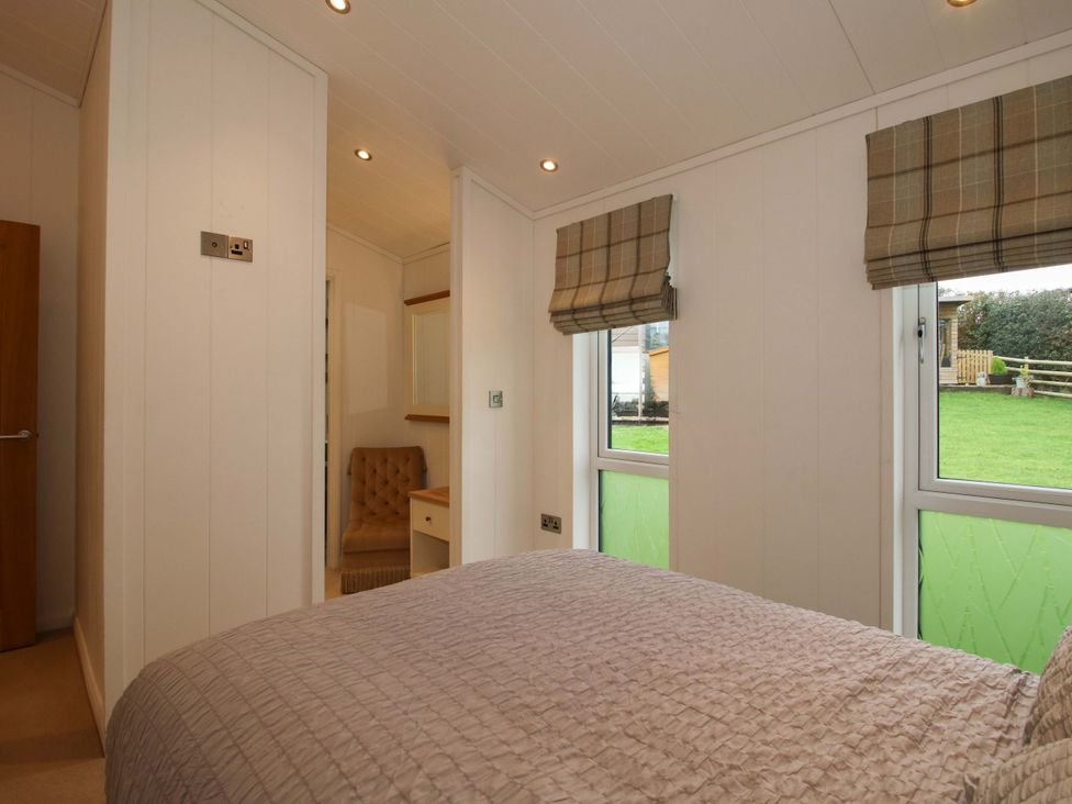A bedroom with a bed and a chair at 5 Hillview Lodges in Cleobury Mortimer