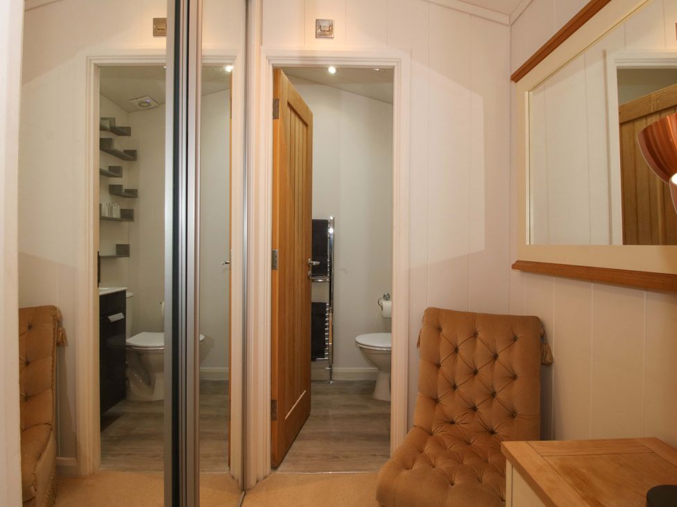 A bathroom with a toilet and shelves at 5 Hillview Lodges in Cleobury Mortimer