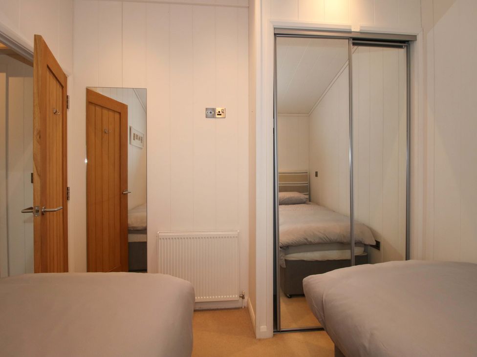 A bedroom with a double bed and a mirror at 5 Hillview Lodges Cleobury Mortimer
