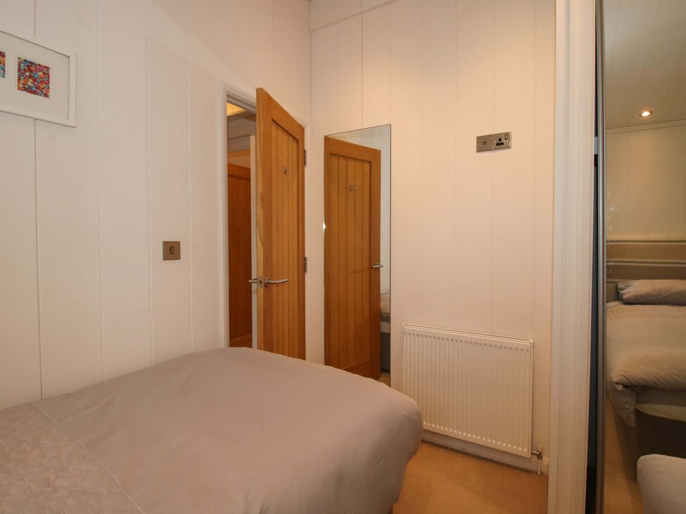A bedroom with doors and a bed at 5 Hillview Lodges in Cleobury Mortimer
