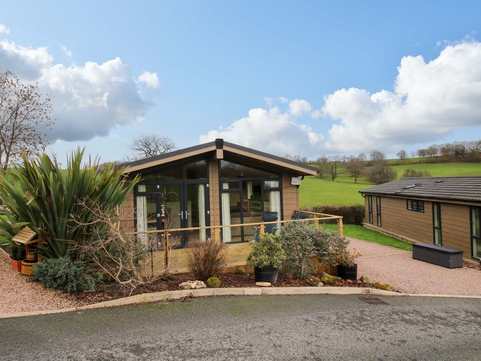 An outdoor area with a log cabin and plants at 5 Hillview Lodges Cleobury Mortimer