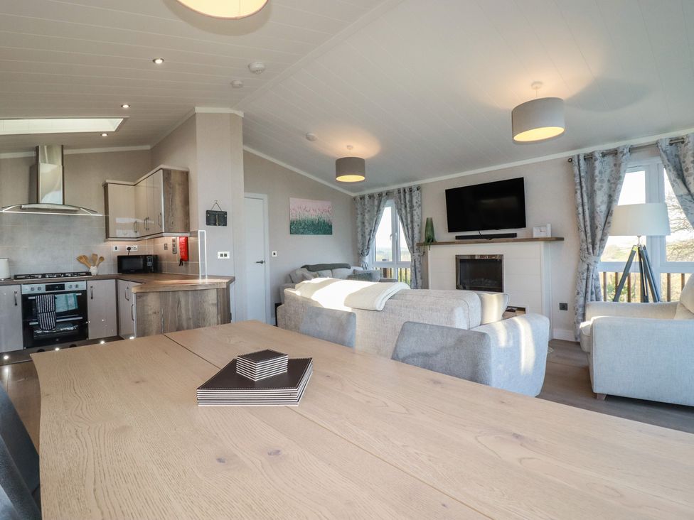 A living room with a kitchen area and dining table at Moorland View