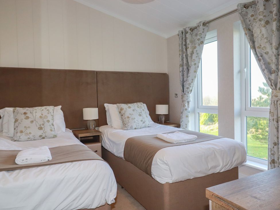 A bedroom with two beds and windows at Moorland View