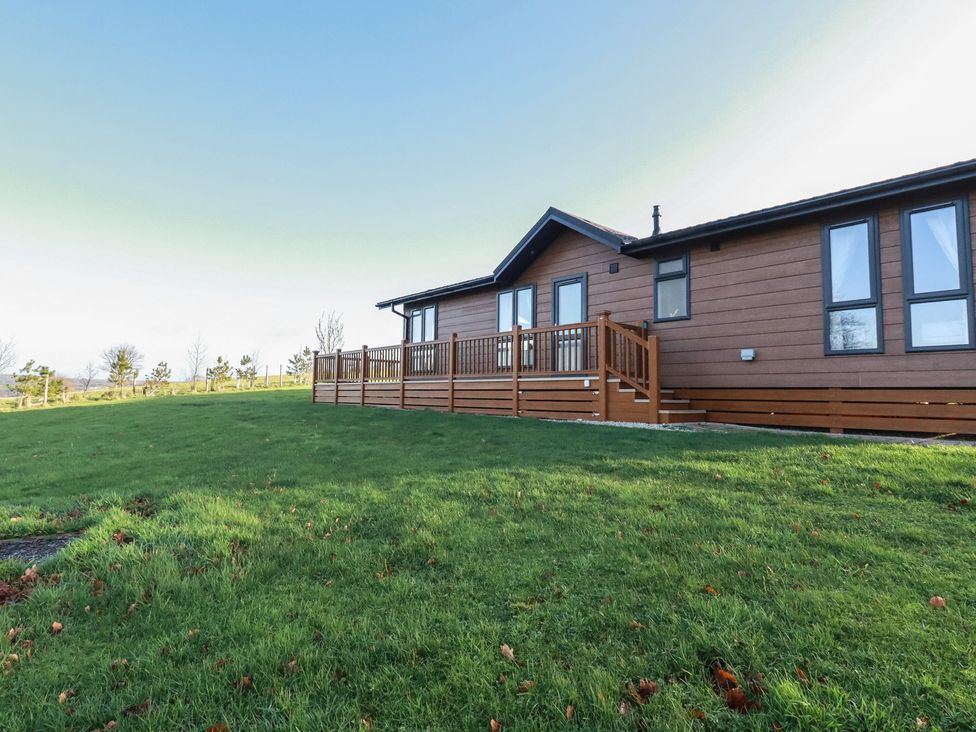 A house with a deck and lawn at Moorland View