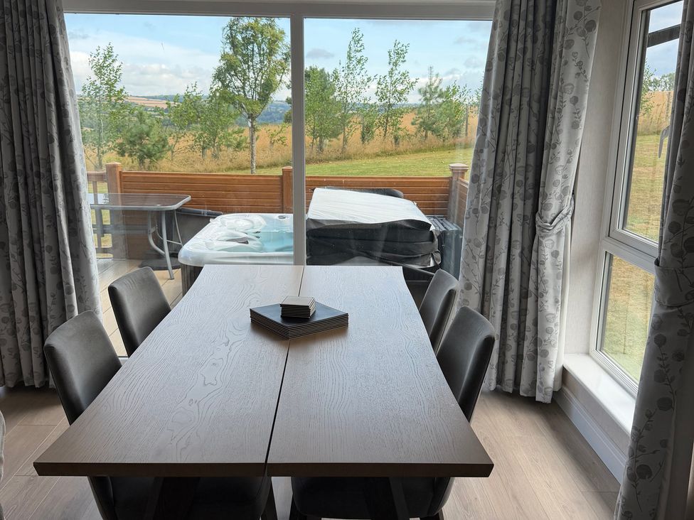 A dining room with a table and chairs at Moorland View in Dobwalls
