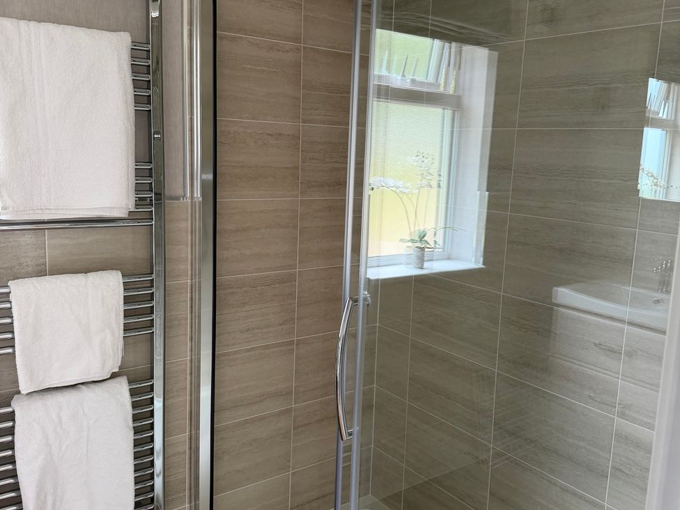 A bathroom with towels on a rack and a shower at Moorland View in Dobwalls
