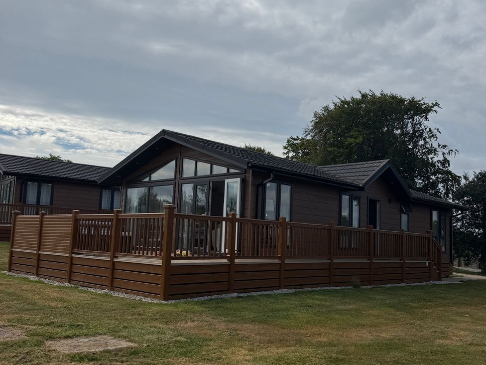 A house with a deck and multiple windows at Moorland View in Dobwalls