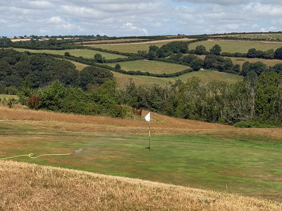 A golf course with a flag and grass at Moorland View in Dobwalls