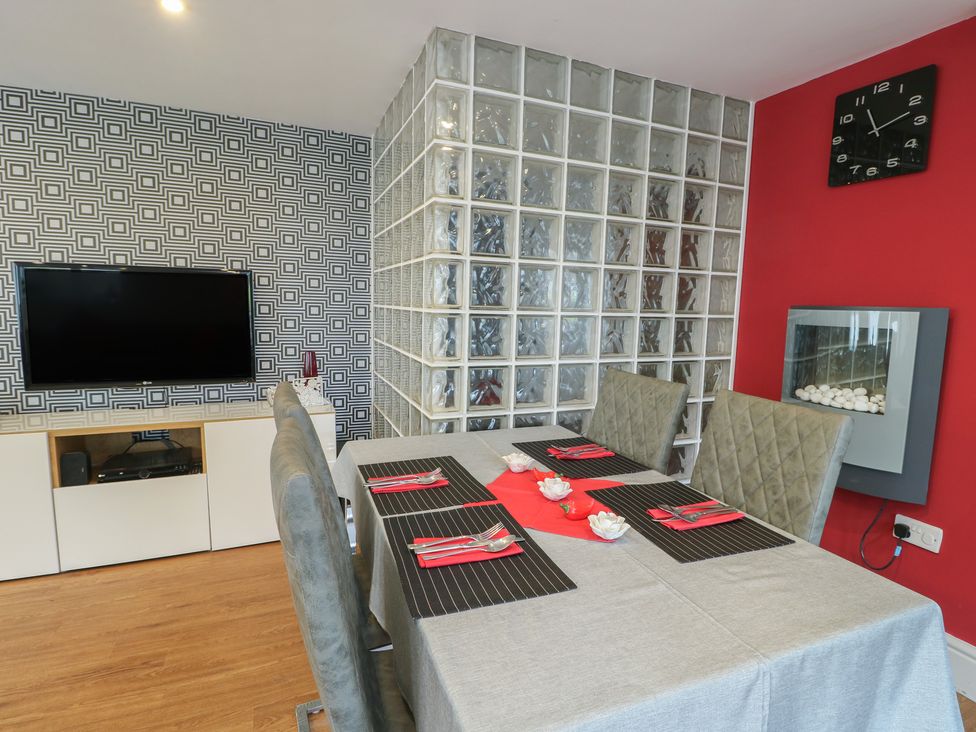 A dining room with a table and chairs at Ty Llyn in Brynteg near Benllech