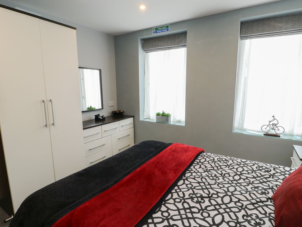 A bedroom with a bed and wardrobe at Ty Llyn Brynteg near Benllech