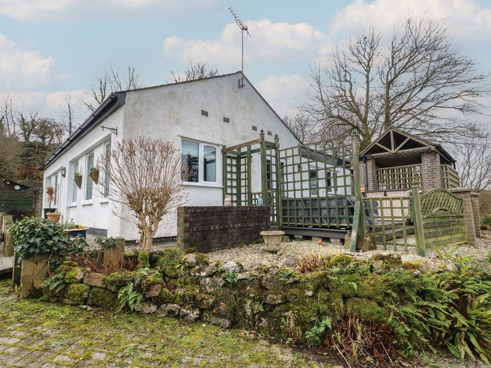 A house with a deck and garden features at Ty Llyn in Brynteg near Benllech
