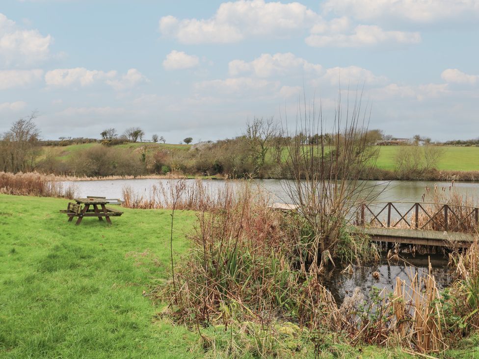 A picnic table near a water body at Ty Llyn in Brynteg near Benllech
