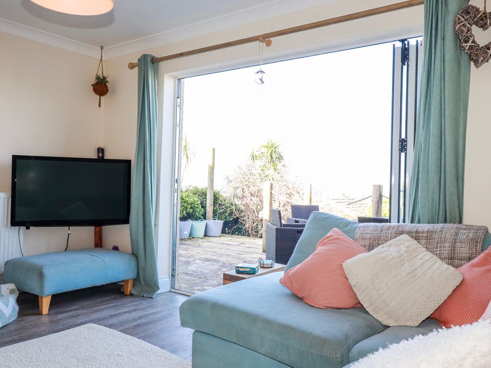 A living room with a sofa and television at 3A Grannys Lane in Perranporth