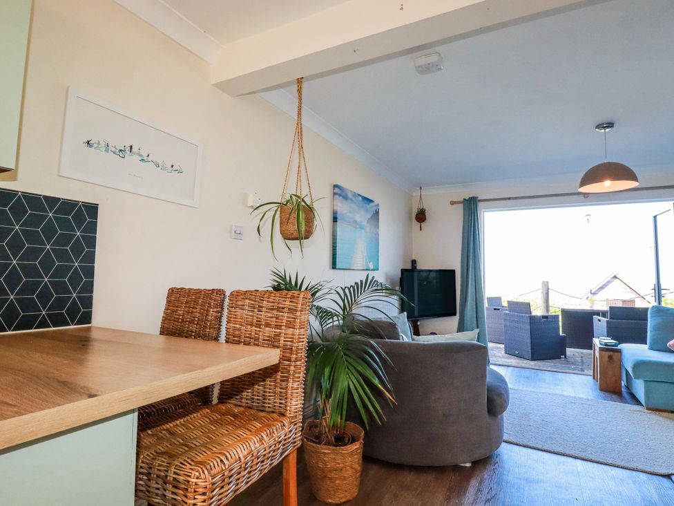A living room with a wooden table and two chairs at 3A Grannys Lane, Perranporth