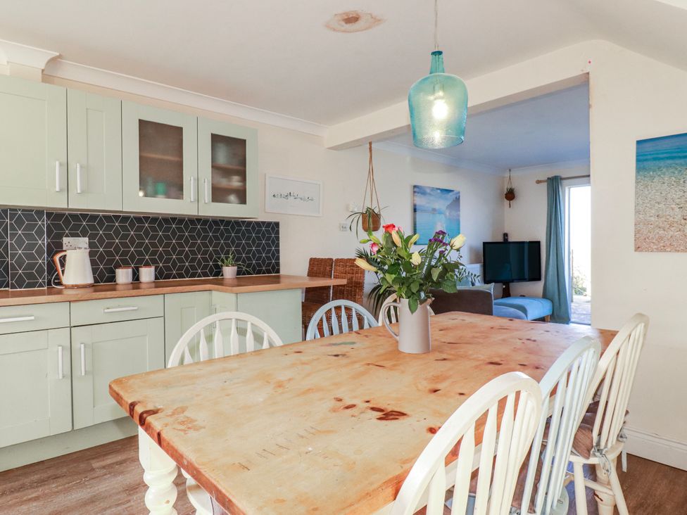 A dining room with a table and chairs at 3A Grannys Lane in Perranporth